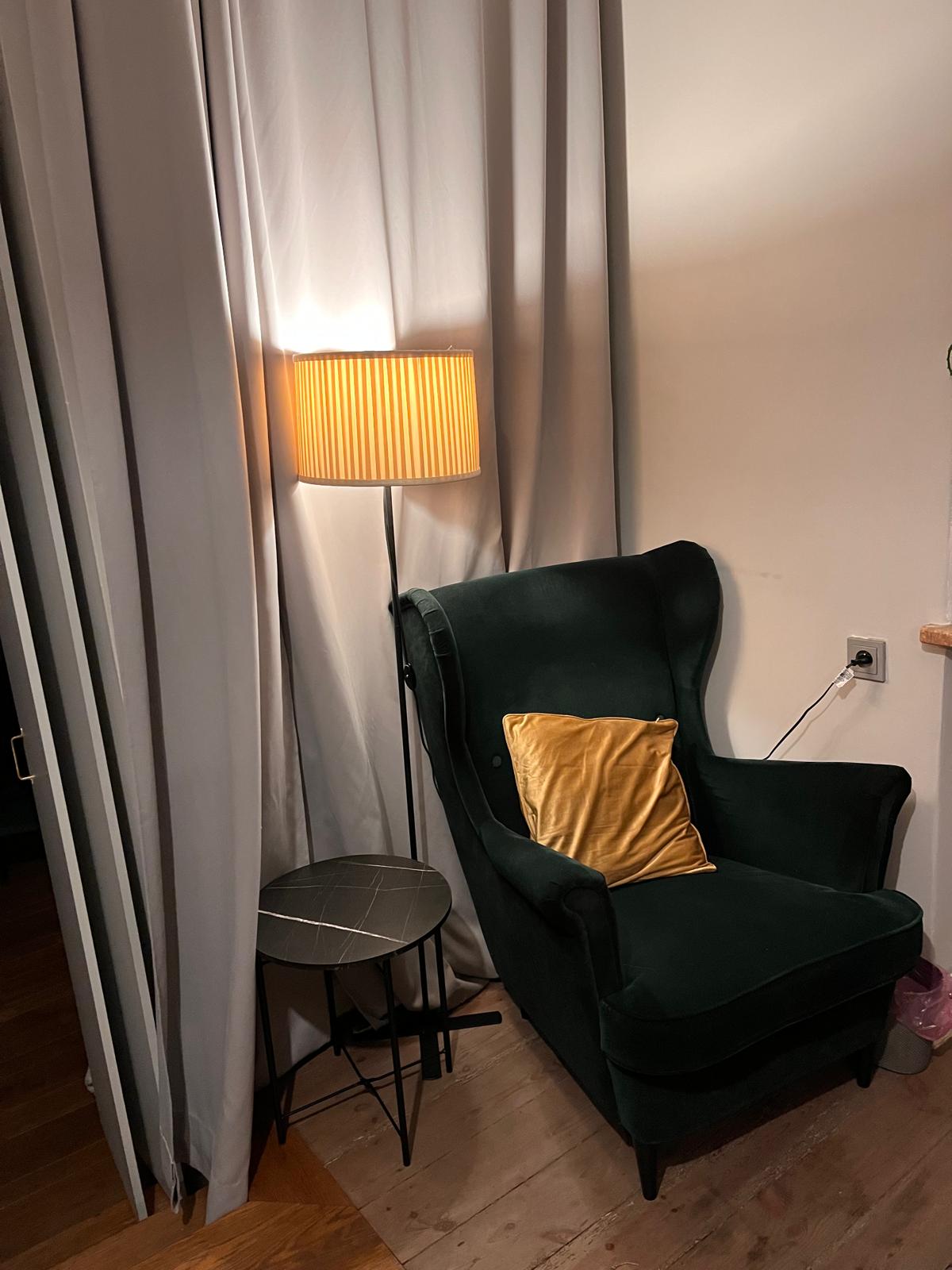 Zielony fotel i lampa w gabinecie